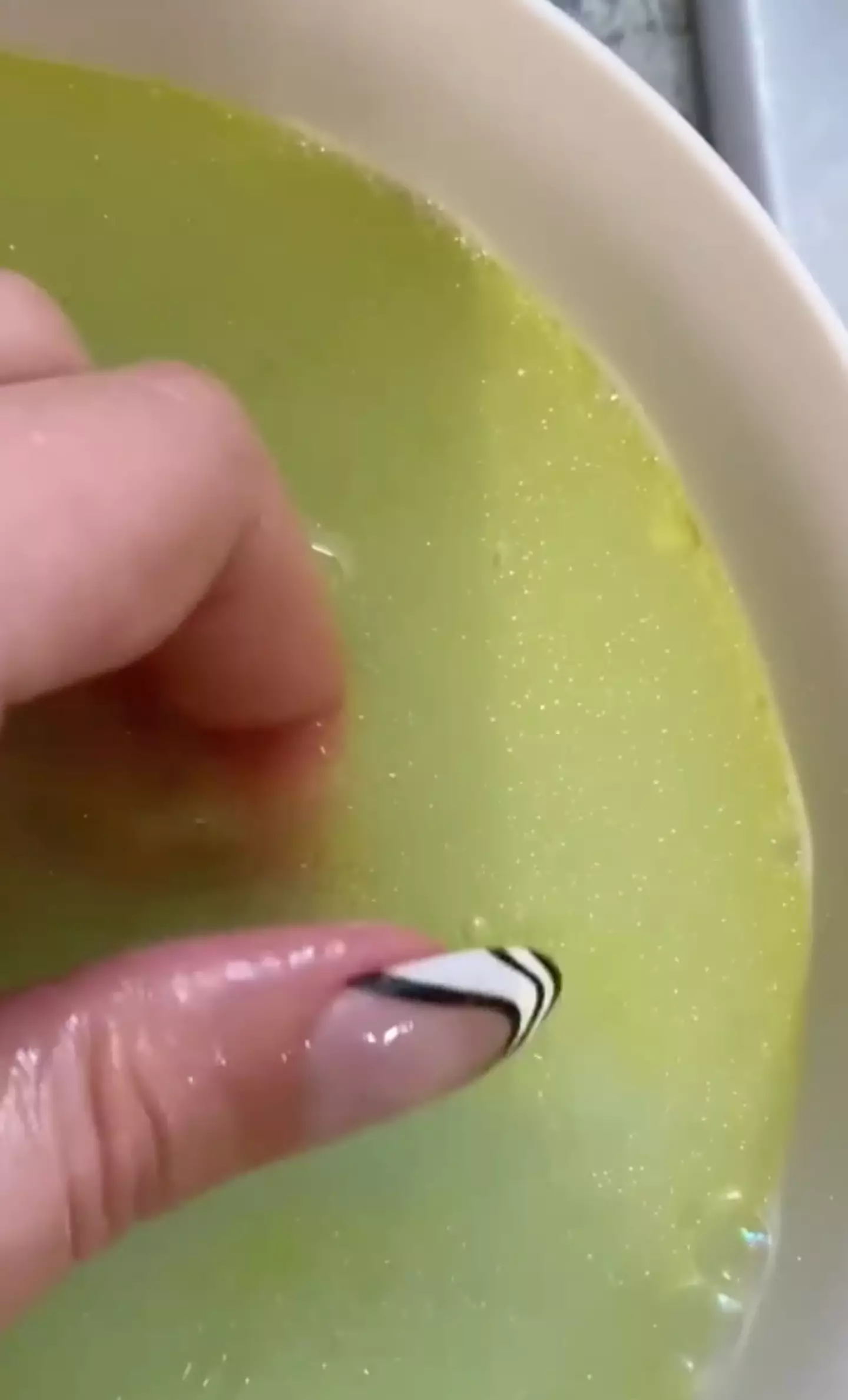 The TikToker soaks her nails in some soap, hot water and oil.