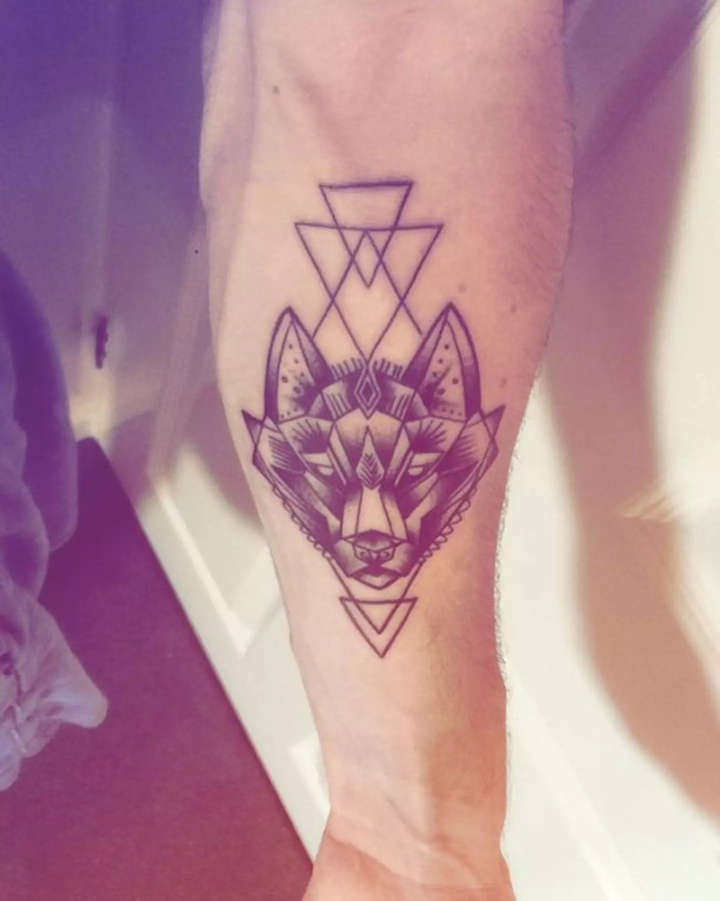 The wolf tattoo is on his arm.