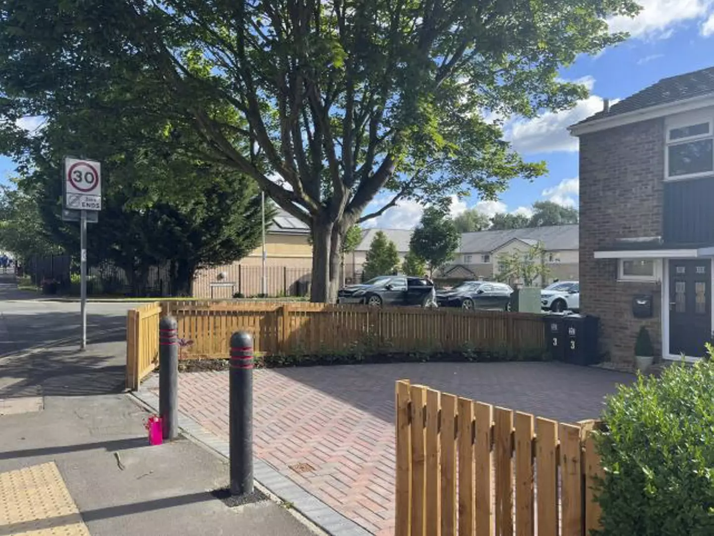 The woman can't use her drive due to the bollards.