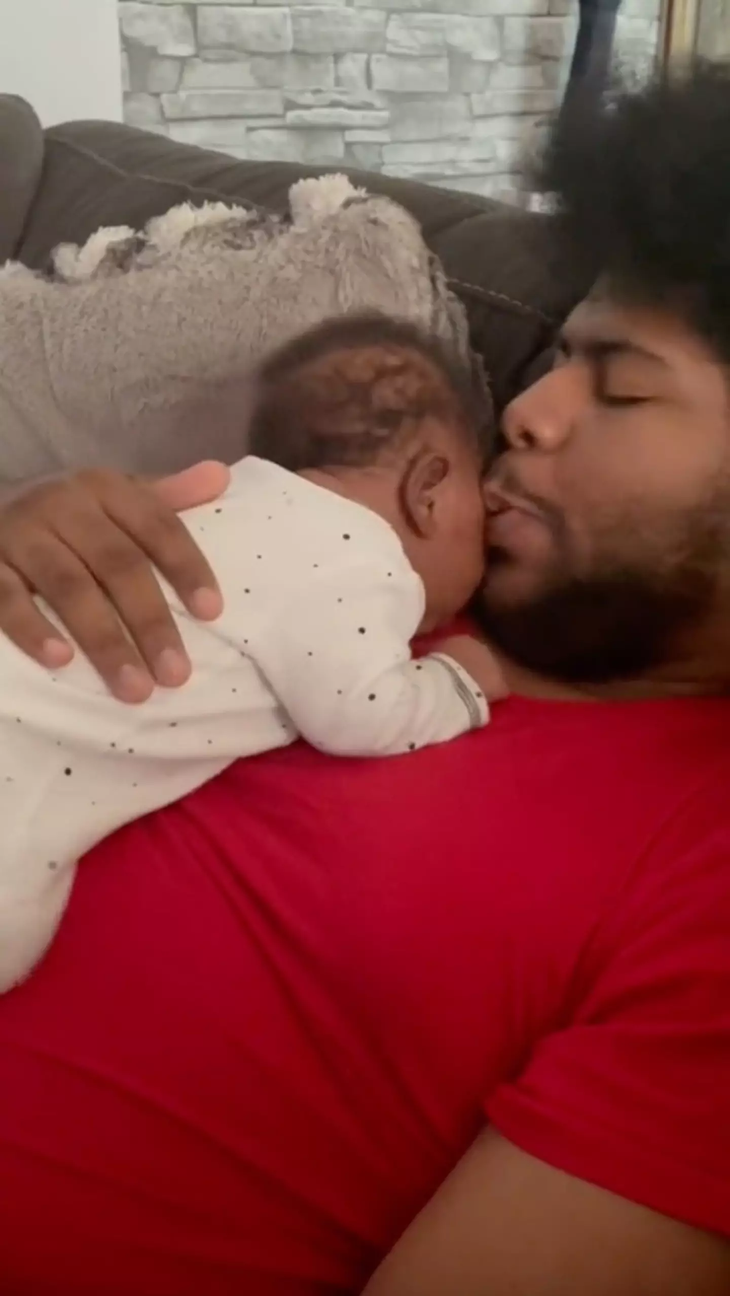 The dad kisses his newborn before she gives him a kiss back.