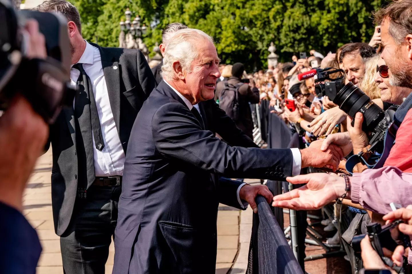 King Charles greeting the crowds outside Buckingham Palace.