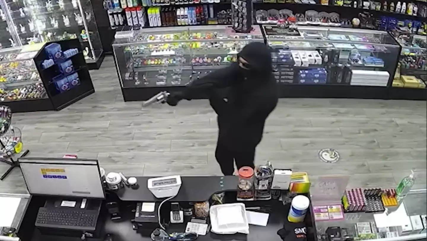 Security footage caught the moment a masked man armed with what looked like a gun walked into a shop and attempted to rob it.
