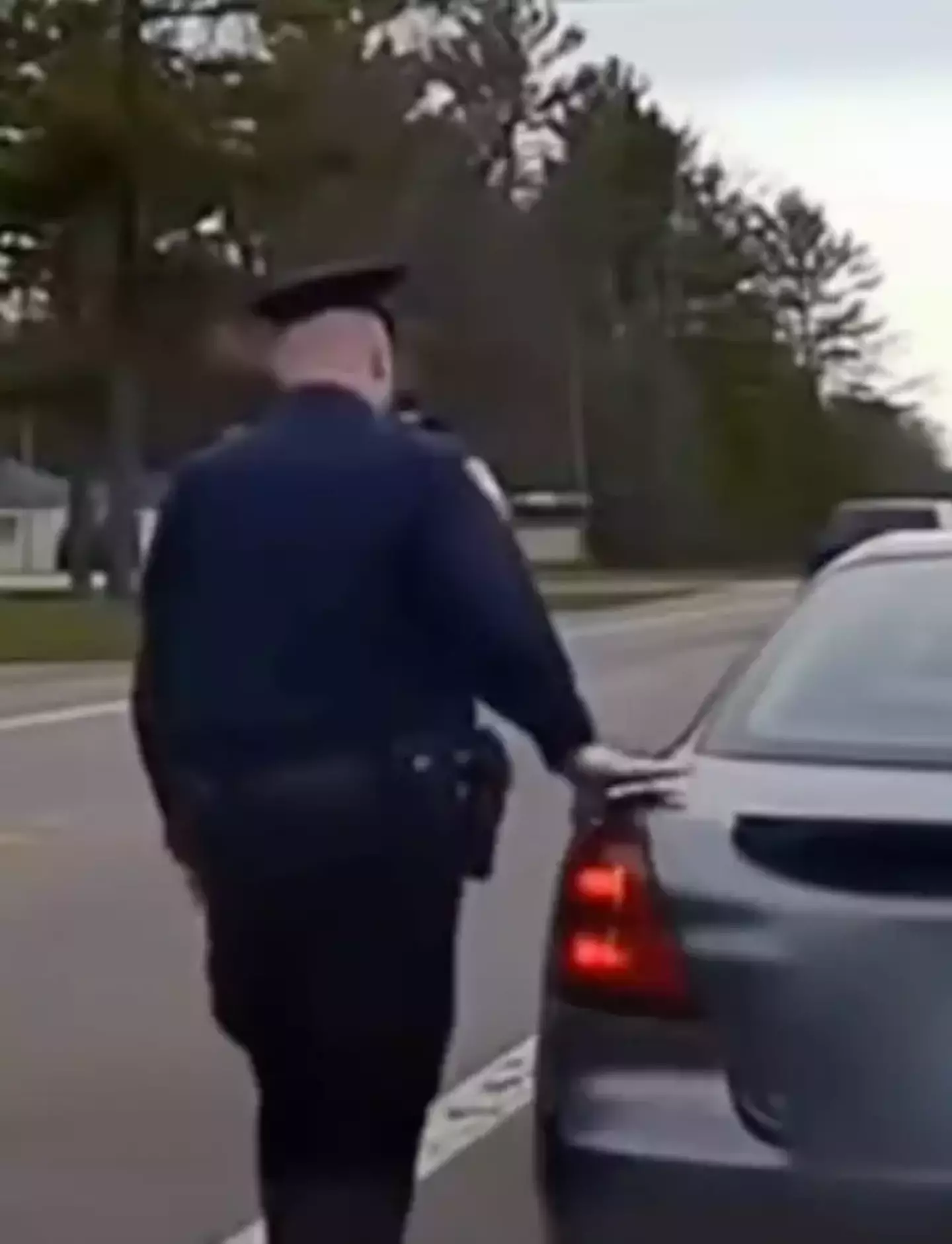 The police have a reason for touching the back of a car.