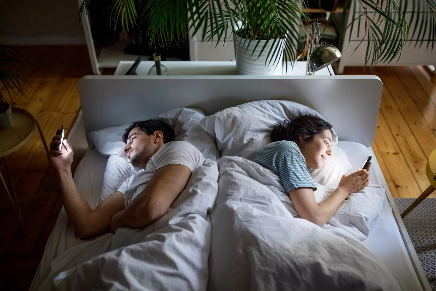 Many couples find they're too tired to get intimate at night, and often resort to bad habits like doom scrolling instead (Getty Stock Image)
