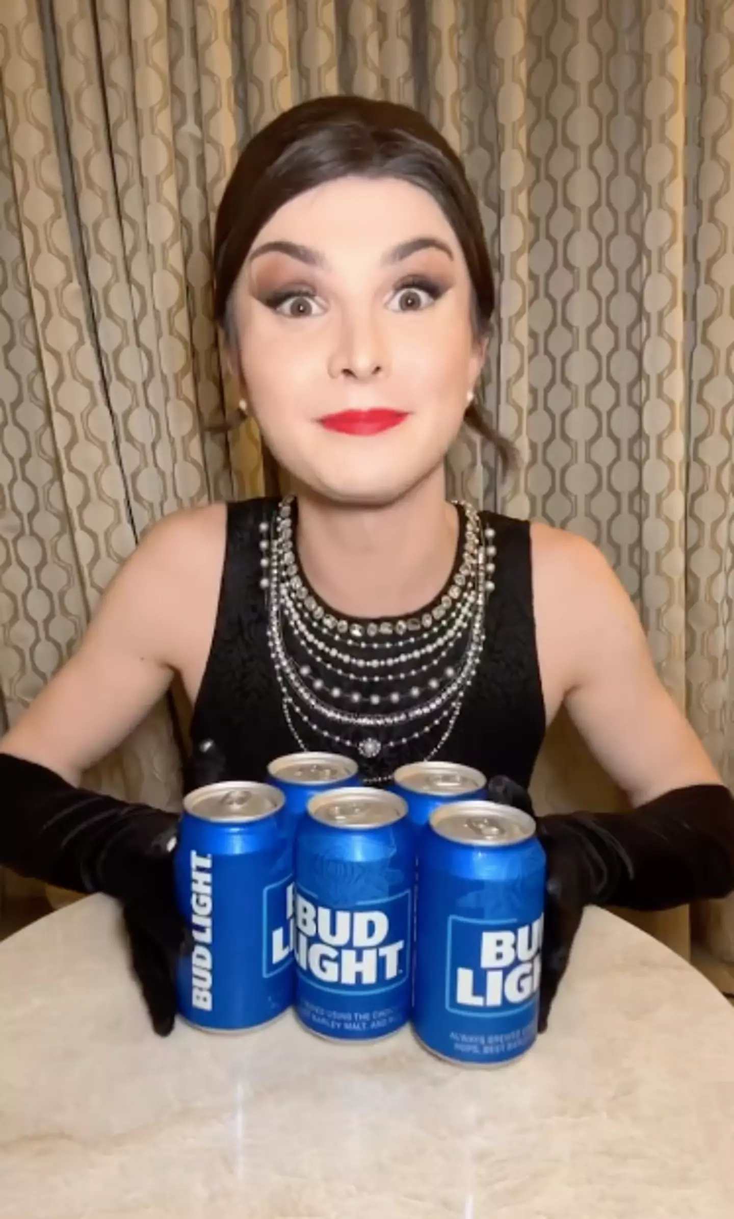 Dylan Mulvaney shows her fans the cans of beer she received from Bud Light.
