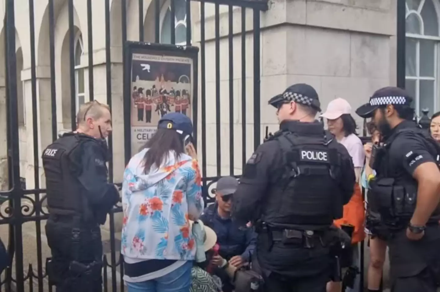 Armed officers gathered around the woman after she fainted. (YouTube/@busk1976)