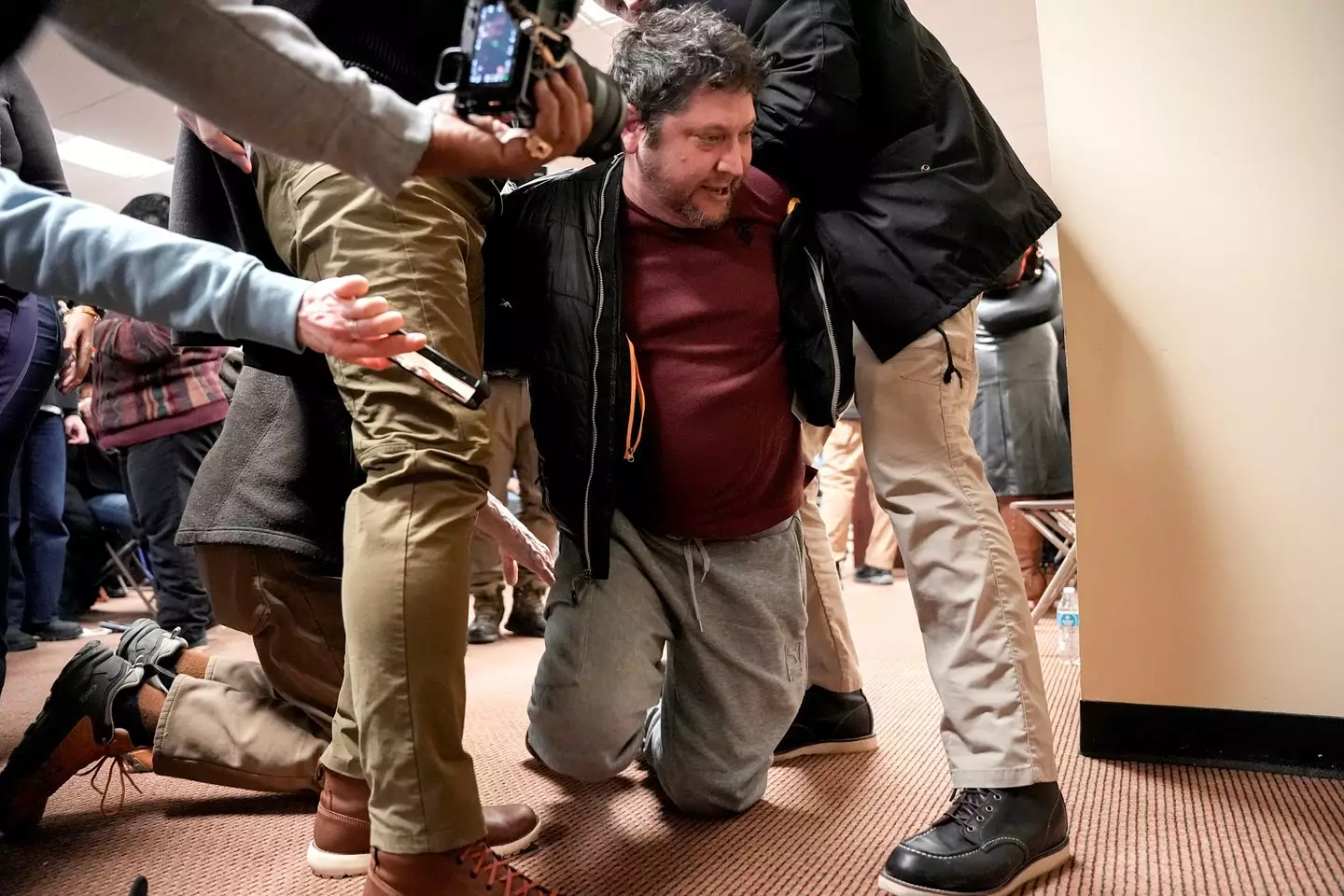 The assaliant was tackled to the ground after spraying Ilhan Omar at the town hall (Angelina Katsanis/Bloomberg via Getty Images)