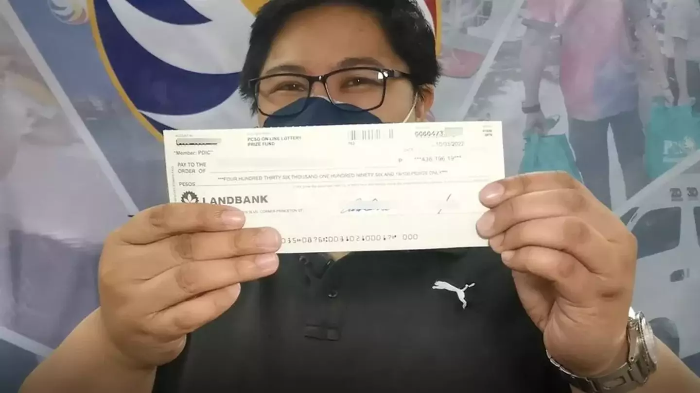 A lucky winner with their cheque.