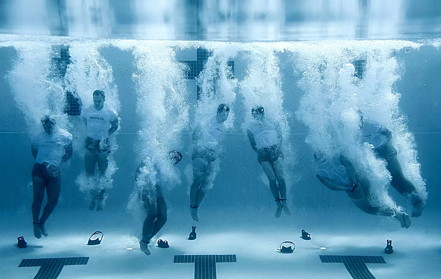 U.S Navy SEALs sink to the bottom of a pool with their hands and feet bound during drown proofing exercises at the Naval Special Warfare Center June 23, 2012.