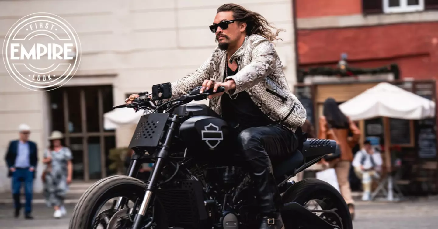 Momoa looks cool as hell on the back of a motorbike with his luscious locks blowing in the breeze.