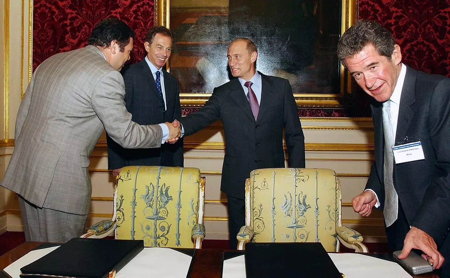 Mikhail Fridman shakes hands with Vladimir Putin.