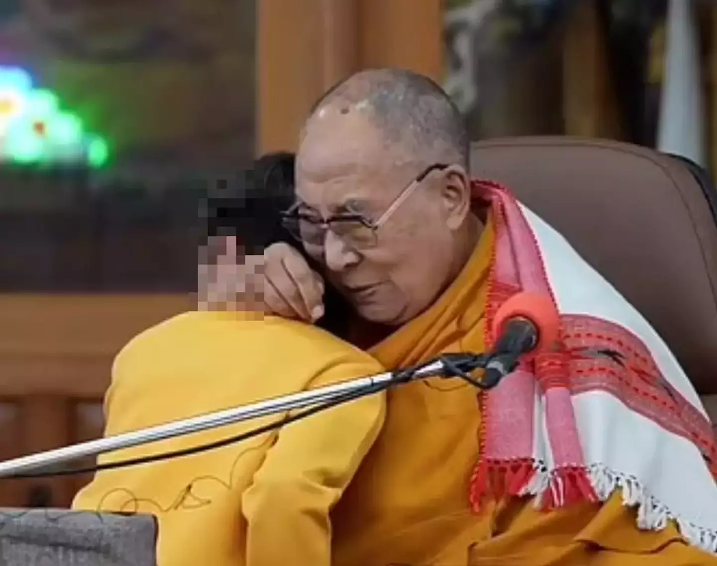 Footage of the Dalai Lama shows him embracing and kissing the boy.