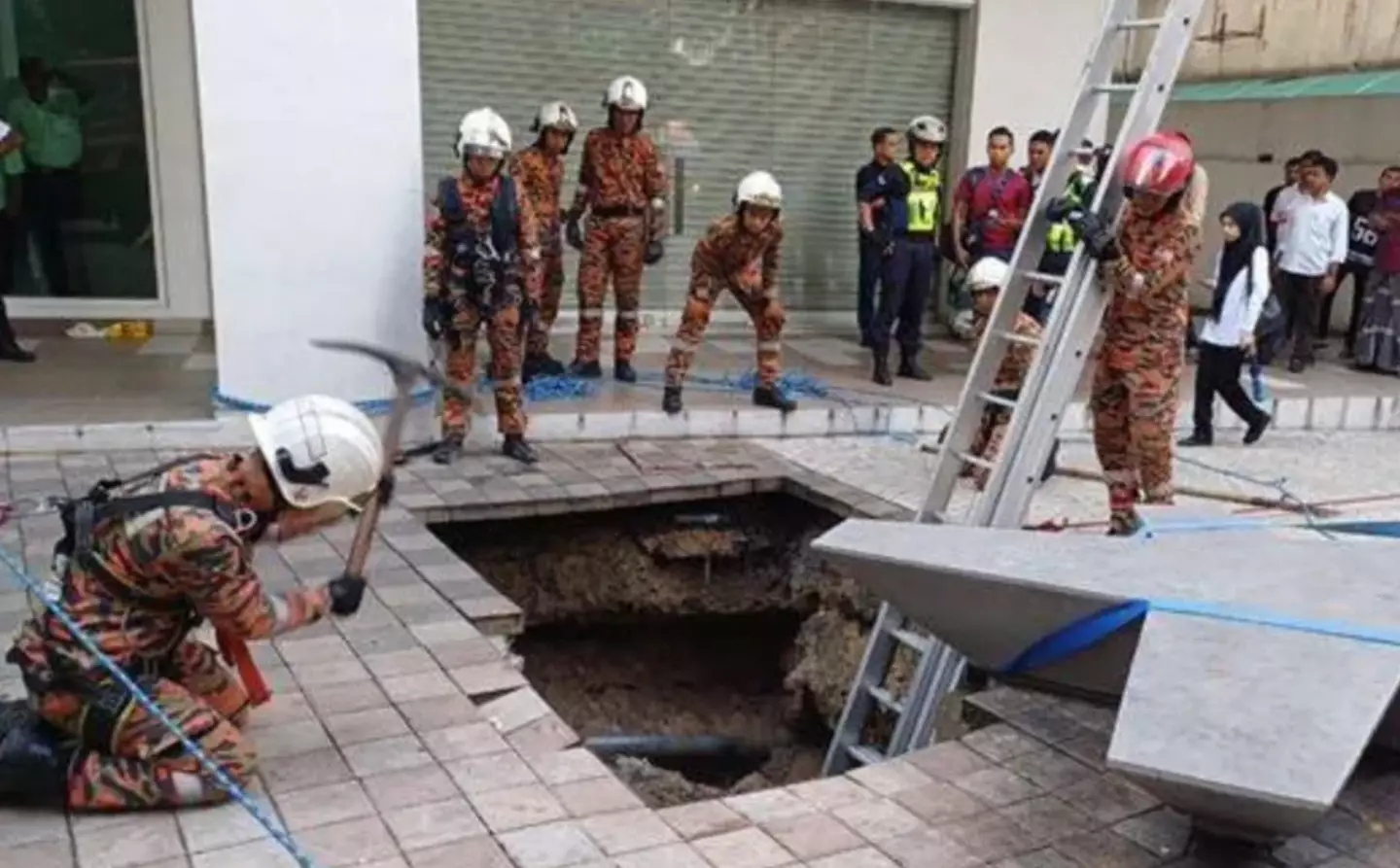 Emergency services are searching for a woman who fell into a sinkhole. (Kuala Lumpur Fire and Rescue Department)