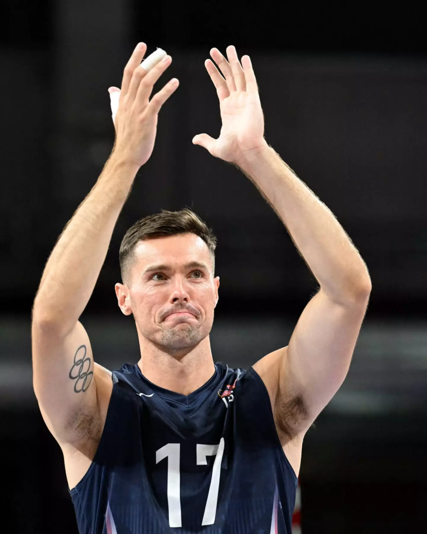 Team USA volleyball player Thomas Jaeschke celebrates after beating Germany during the Paris 2024 Olympics with his tattoo on full show. (NATALIA KOLESNIKOVA/AFP via Getty Images)