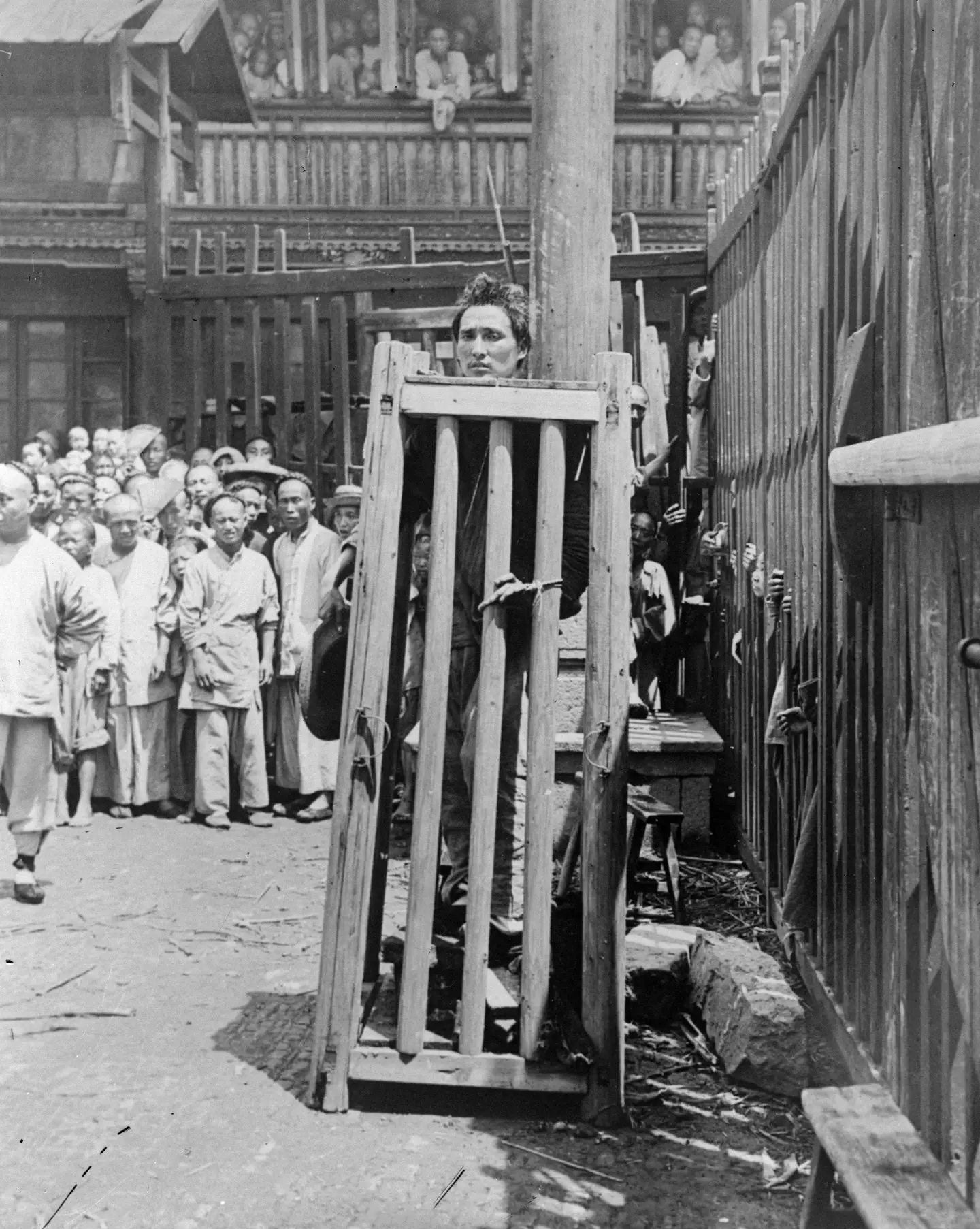 A man in a wooden cage in China. (General Photographic Agency/Getty Images)