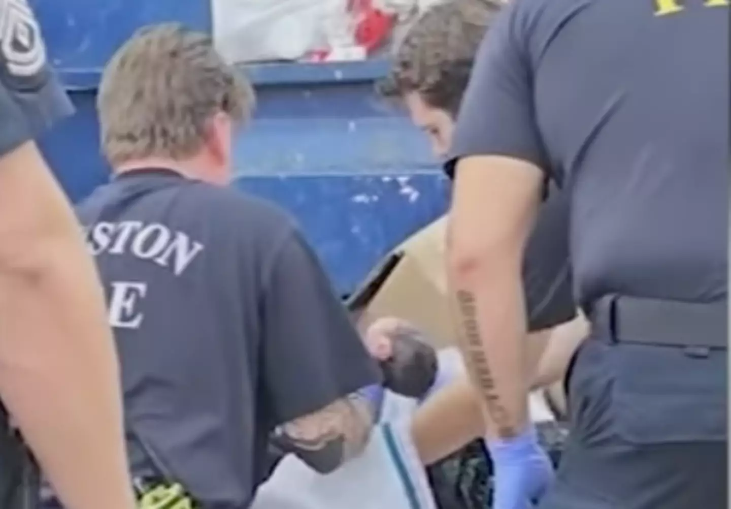 The baby is lifted out of the dumpster by emergency services (YouTube/ ABC13 Houston)