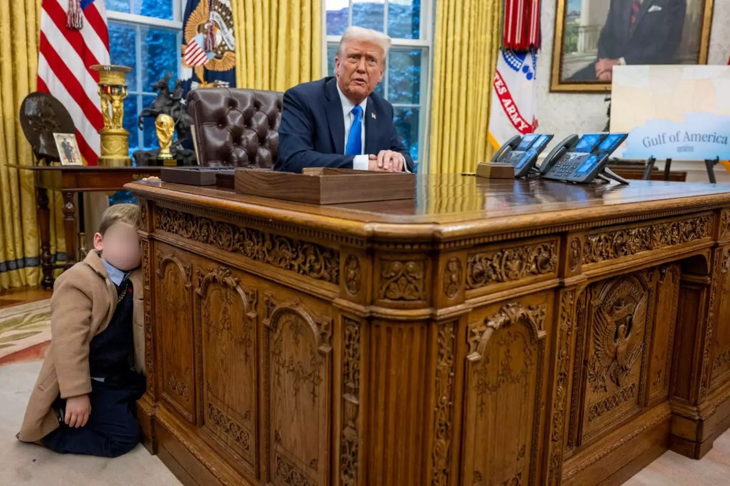 Grimes' bored son X hangs onto Trump's desk in the Oval Office (JIM WATSON/AFP via Getty Images)