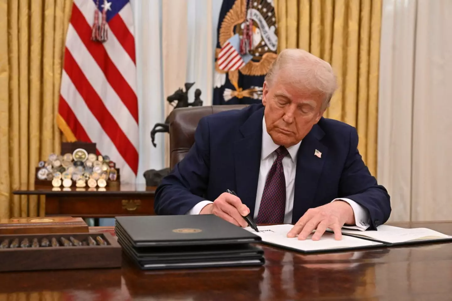President Donald Trump signs an executive order to declassify files of former President John F. Kennedy, former Attorney General Robert F. Kennedy and civil rights leader Martin Luther King Jr., in the Oval Office of the White House (ROBERTO SCHMIDT/AFP via Getty Images)