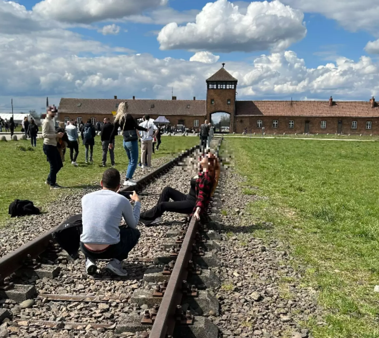 Tourists pose for picture outside Auschwitz.
