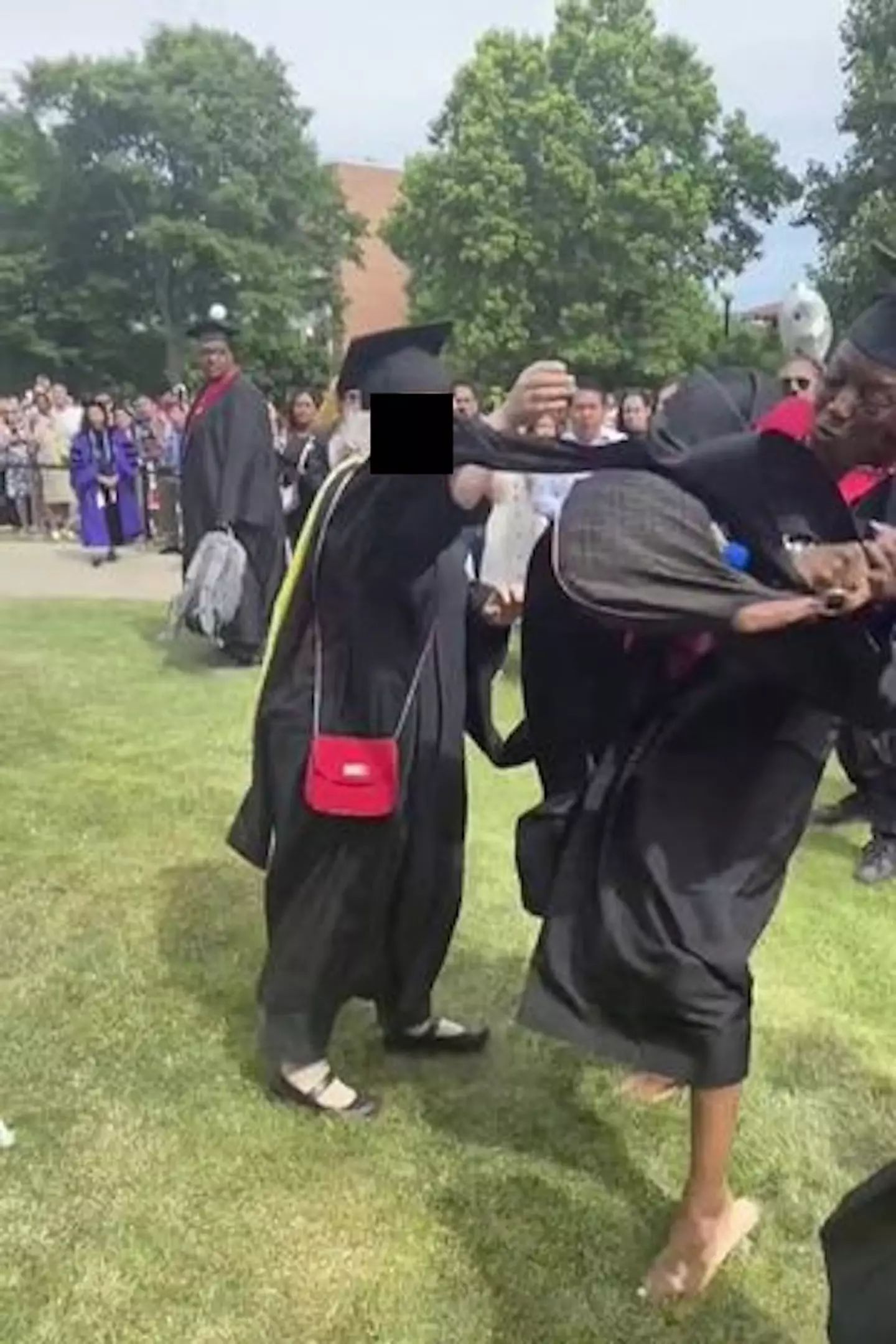 A woman who's name was being called out at a graduation ceremony angrily snatched the microphone from the administrator, later accusing her of reading names 'super fast for some black people'.