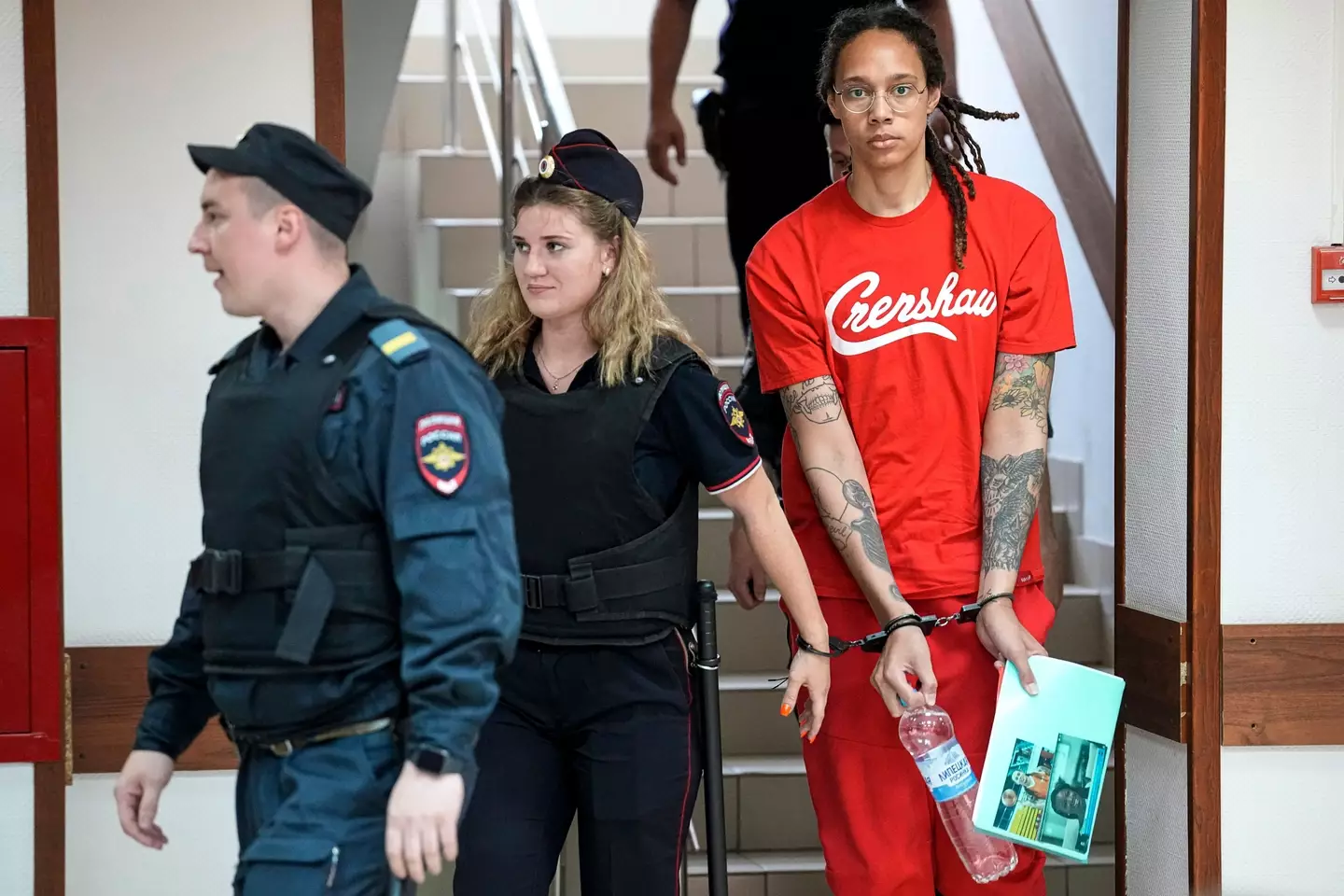 The basketballer was holding a picture of her wife as official led her away in handcuffs.