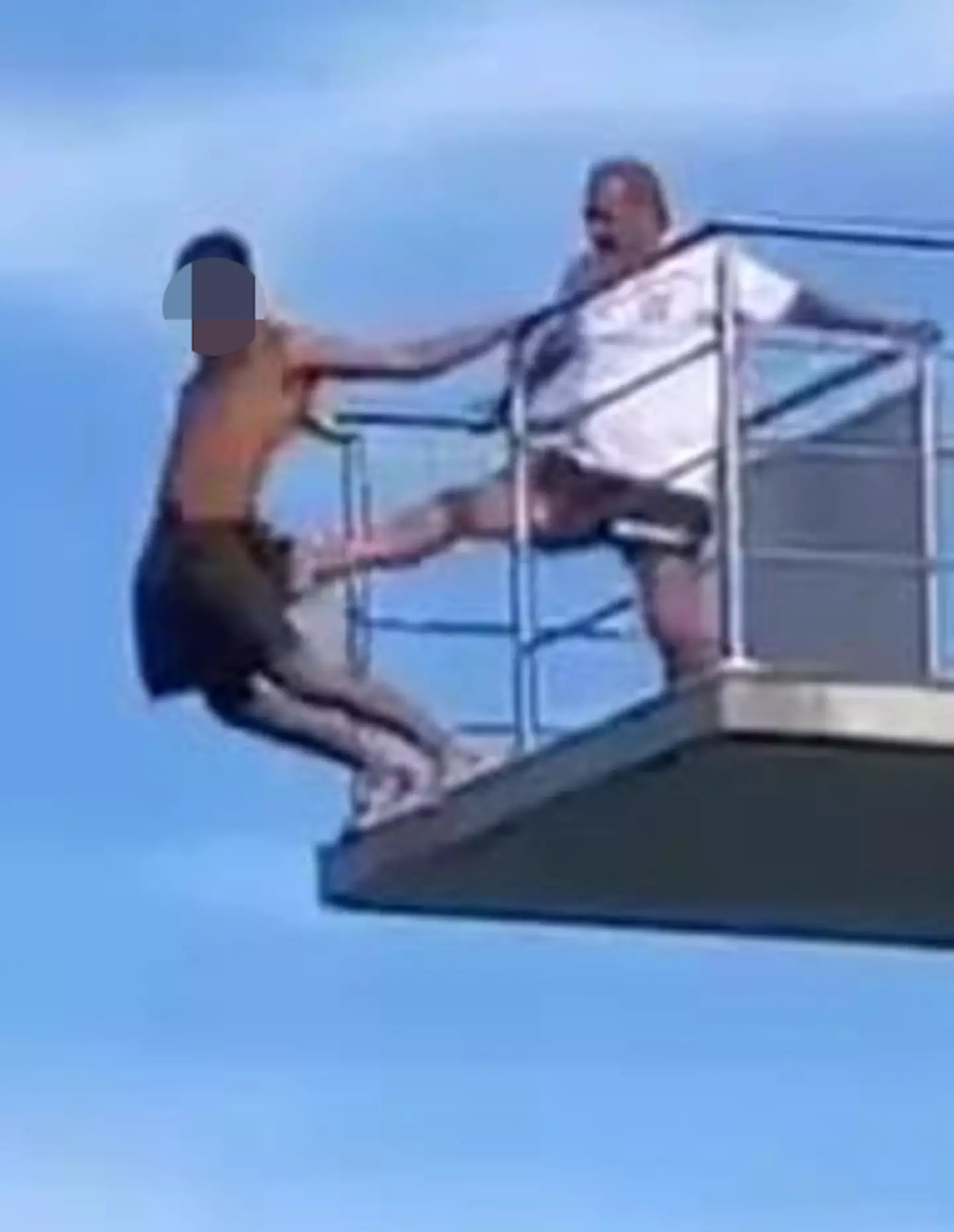 A video captured in Austria appears to show a young man hesitating at the top of a diving board before a lifeguard decides to kick him off.