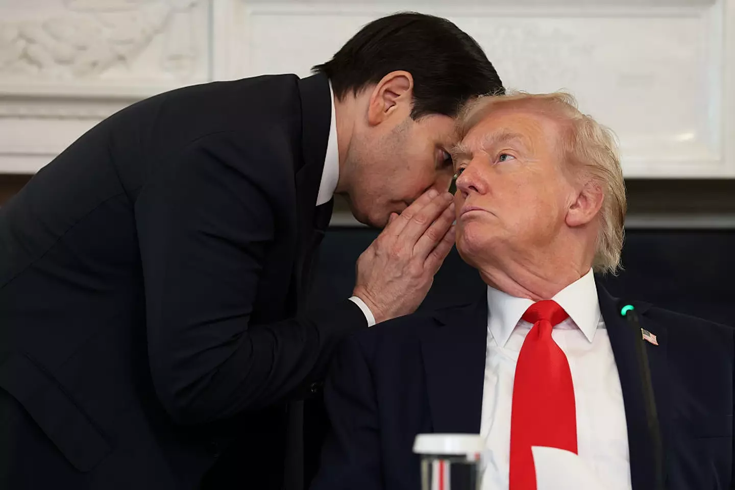 Secretary of State Marco Rubio hands a note to President Donald Trump as he whispers something in his ear during a meeting at the White House (Anna Moneymaker/Getty Images)