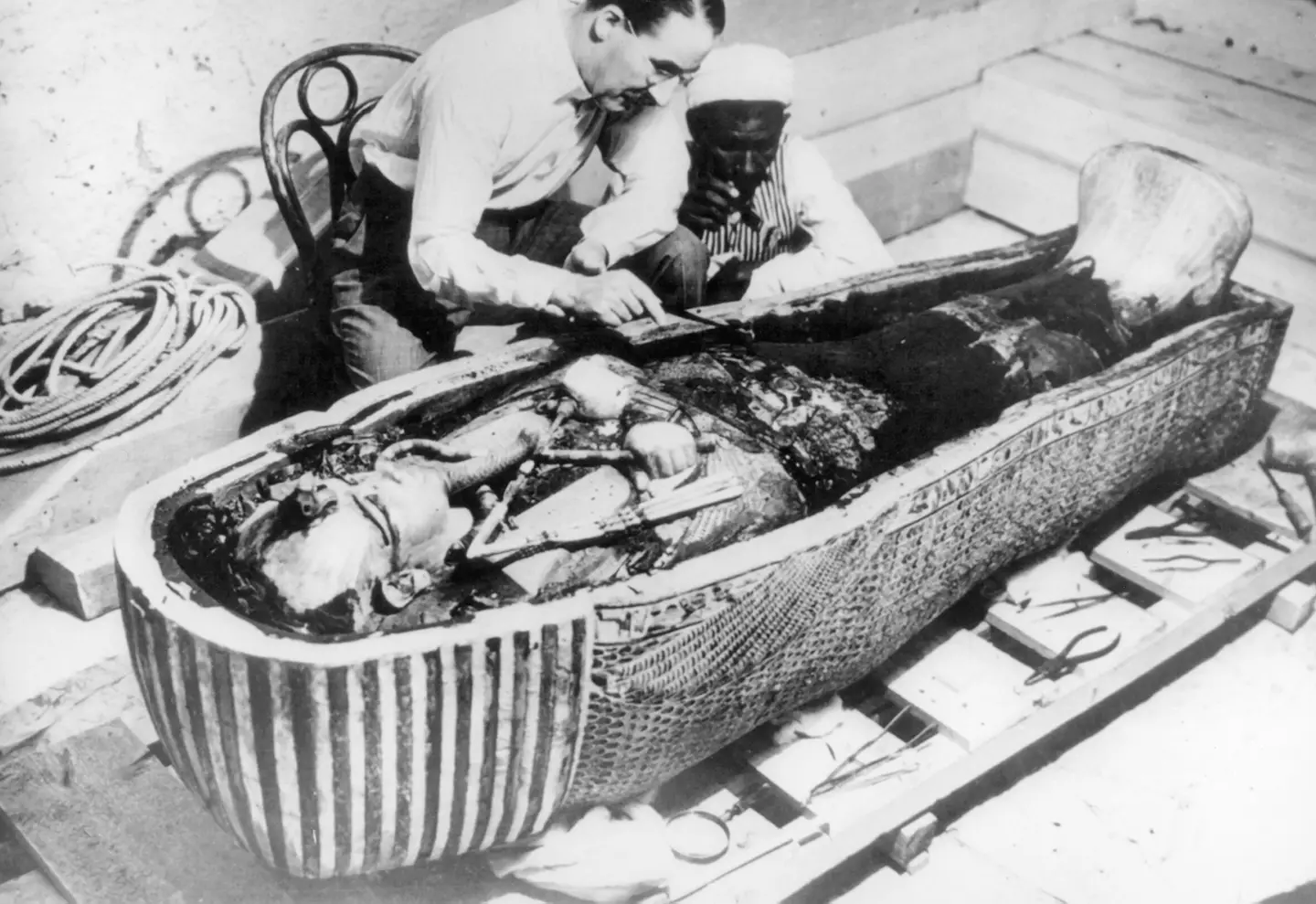 Howard Carter examining Tutankhamun's sarcophagus.