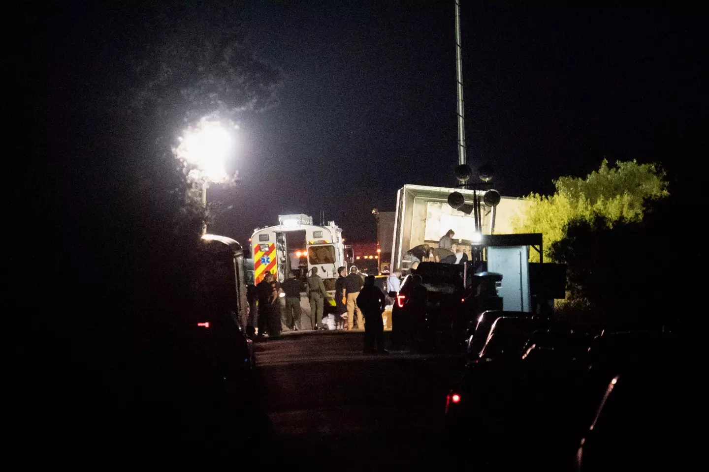 Law enforcement officers work at the scene where people were found dead inside a trailer truck in San Antonio.