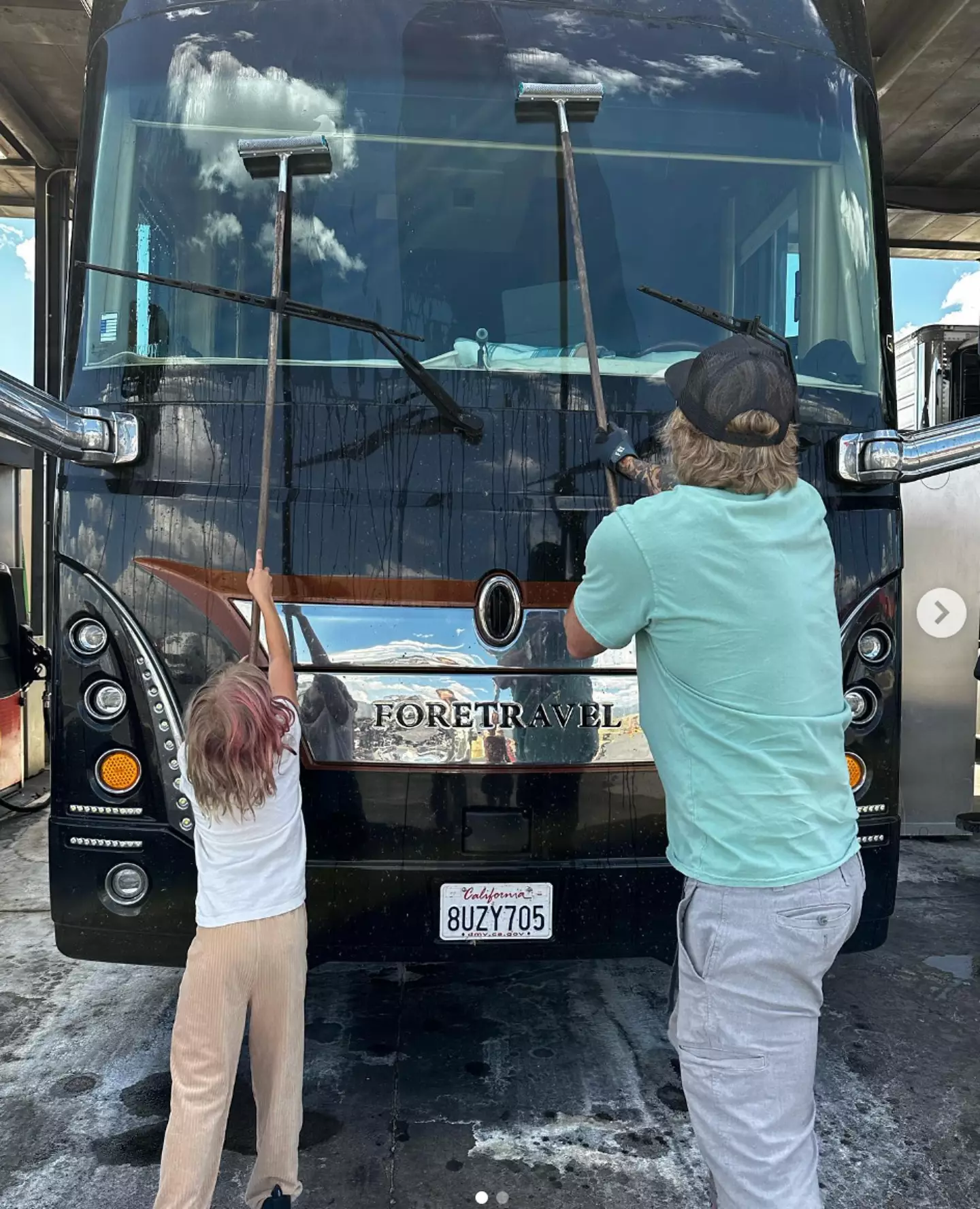 Dax and one of his children cleaning an RV.