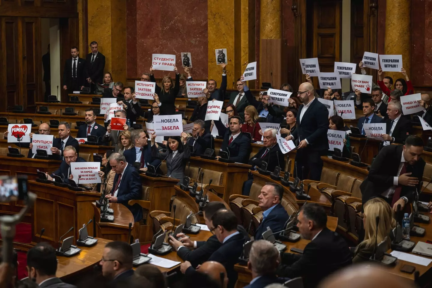 Protestors held up signs and set off smoke bombs and tear gas in parliament in Serbia (ANDREJ ISAKOVIC/AFP via Getty Images)