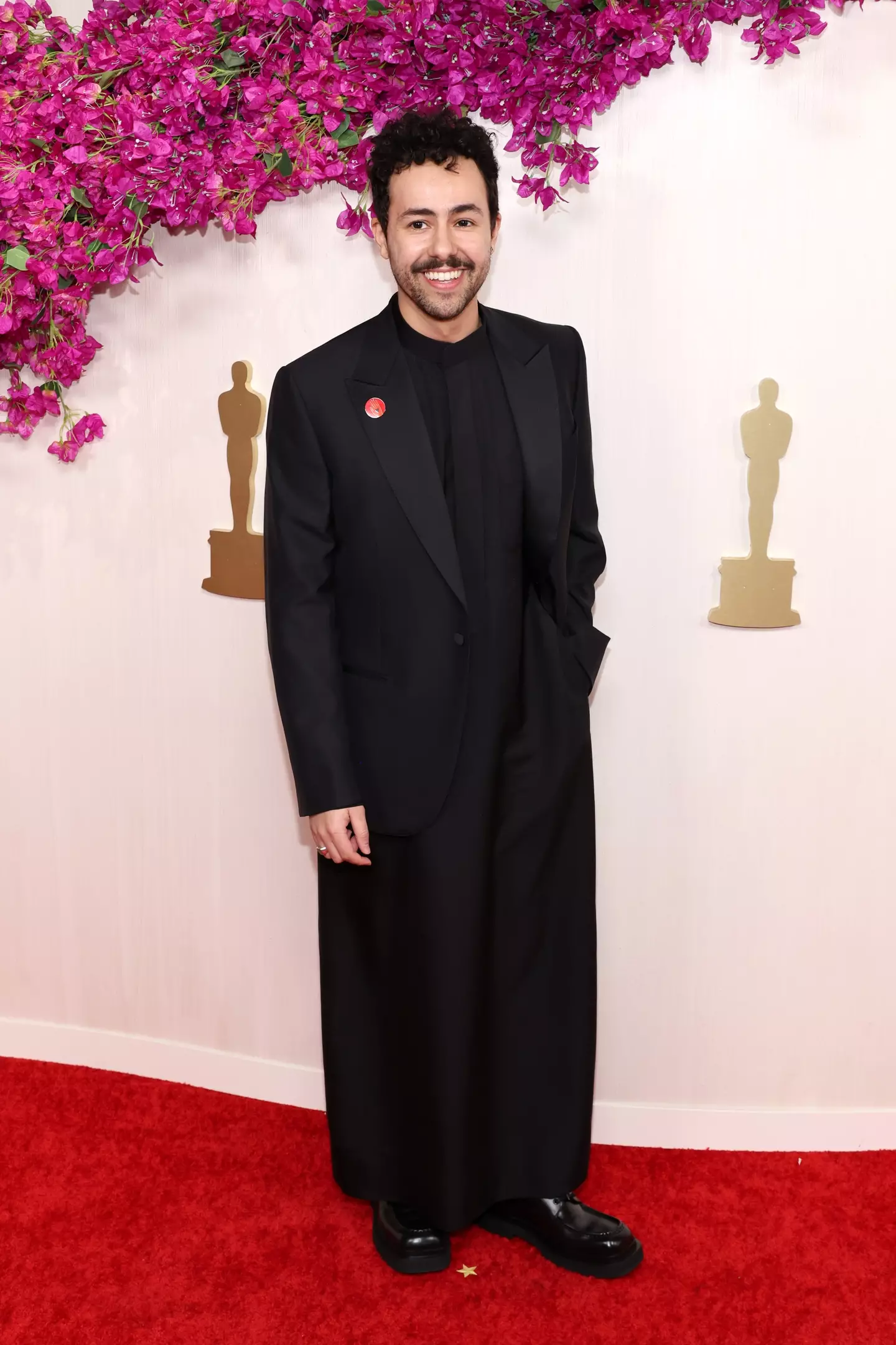Poor Things' Ramy Youssef wearing a pin.