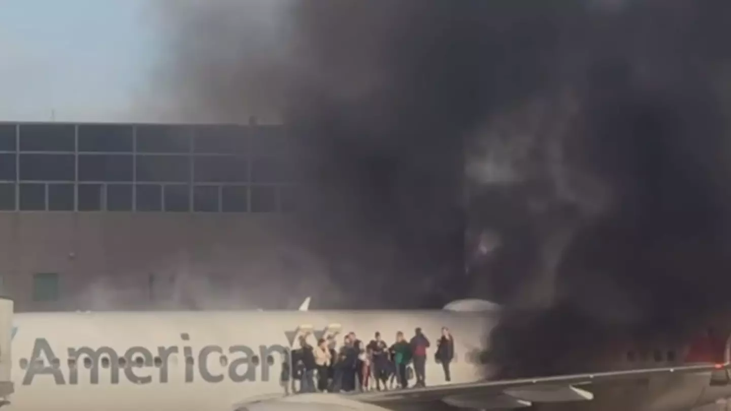 American Airlines plane bursts into flames forcing passengers onto aircraft wing
