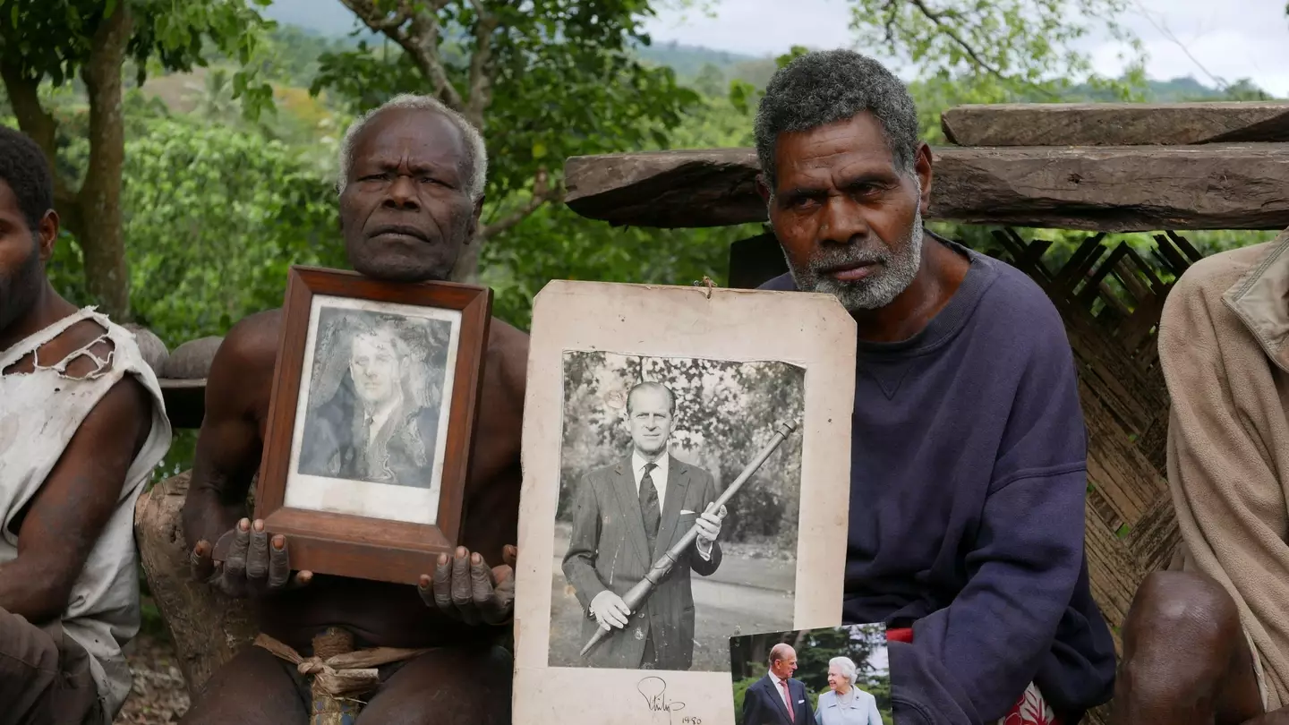 Village chief Jack Malia from Tanna island holds pictures of Britain's Prince Philip and Queen Elizabeth II.