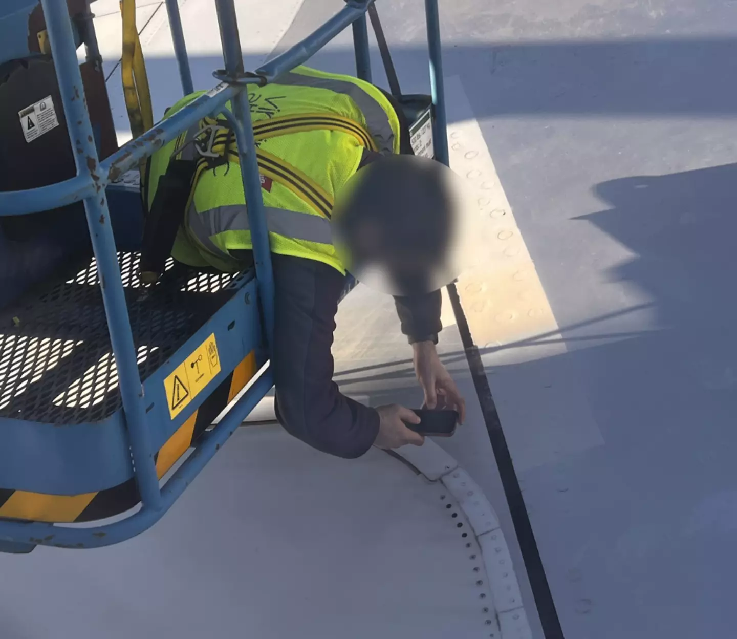 Phil watched the engineer look at the wing.