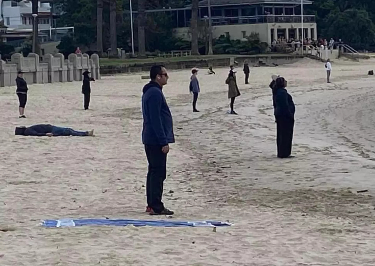 The group were pictured standing separately on the beach.