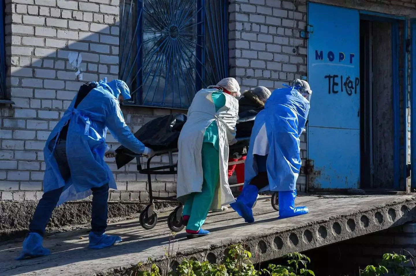 Hospital workers transport a patient to the morgue.