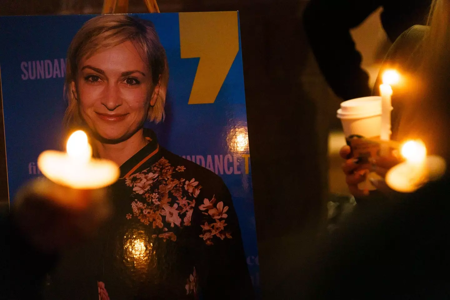 Members of a crowd hold up candles to remember Halyna Hutchins.