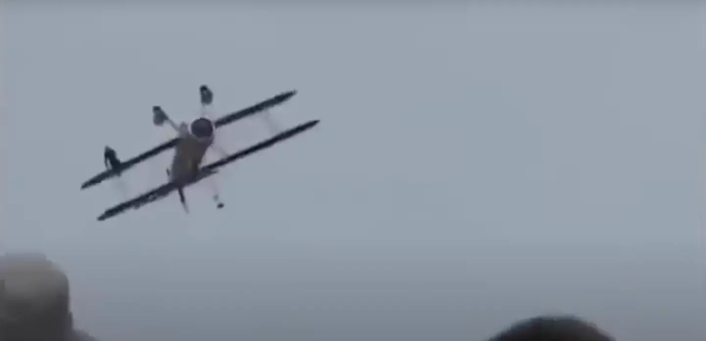 Wing-walker Jane Wicker can be seen sitting on pilot Charlie Schwenker's a mere seconds before death. (YouTube/Bill Omar)