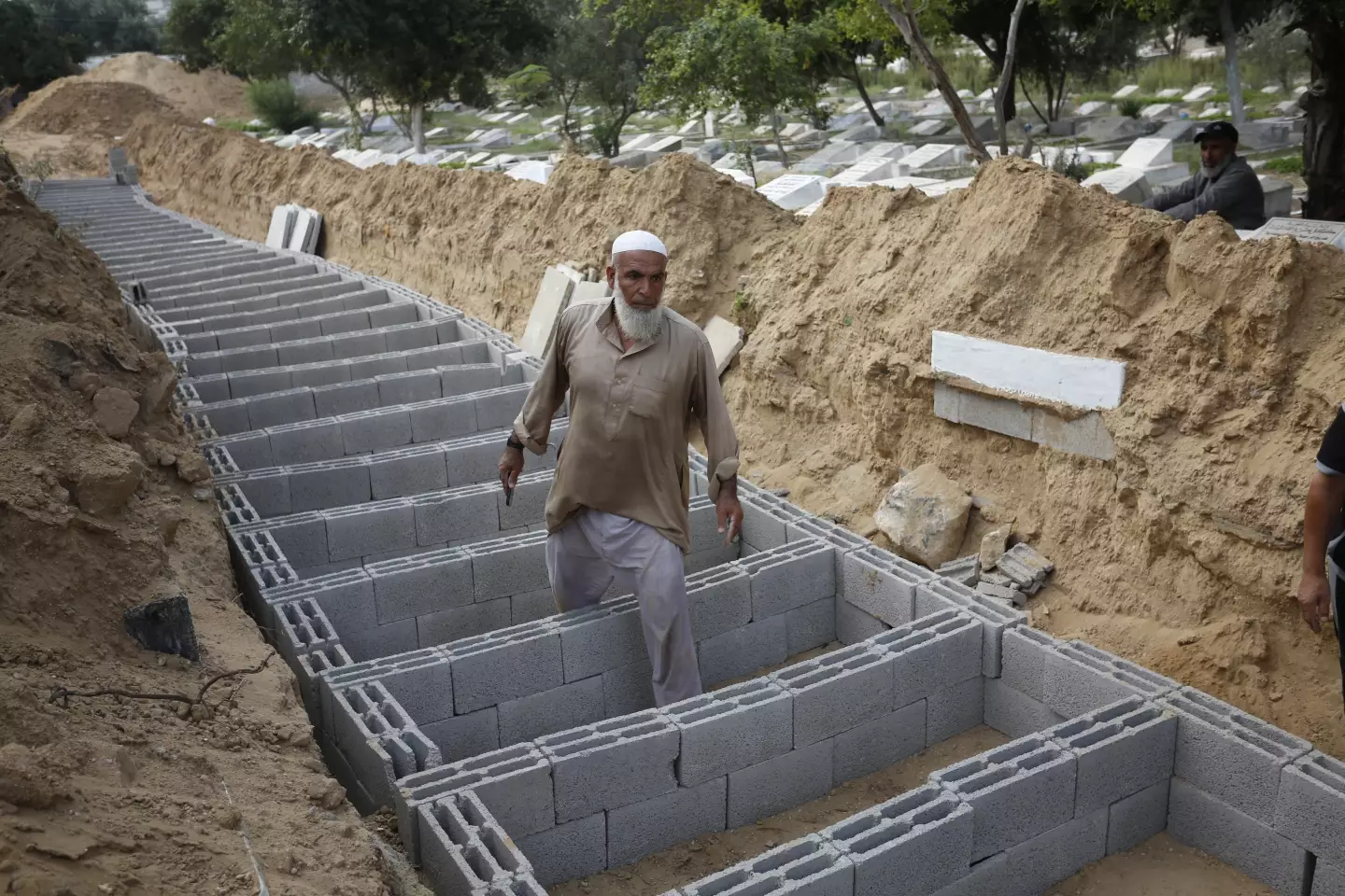 People prepare the graves to bury the dead bodies of Palestinians.