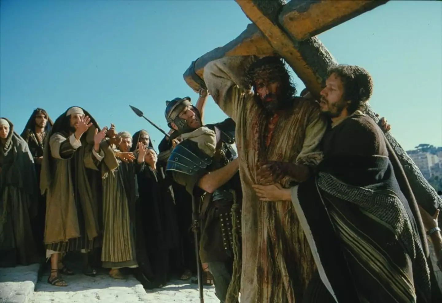 Jim Caviezel playing Jesus Christ as he walks with the cross in The Passion of the Christ. (Twentieth Century Fox)