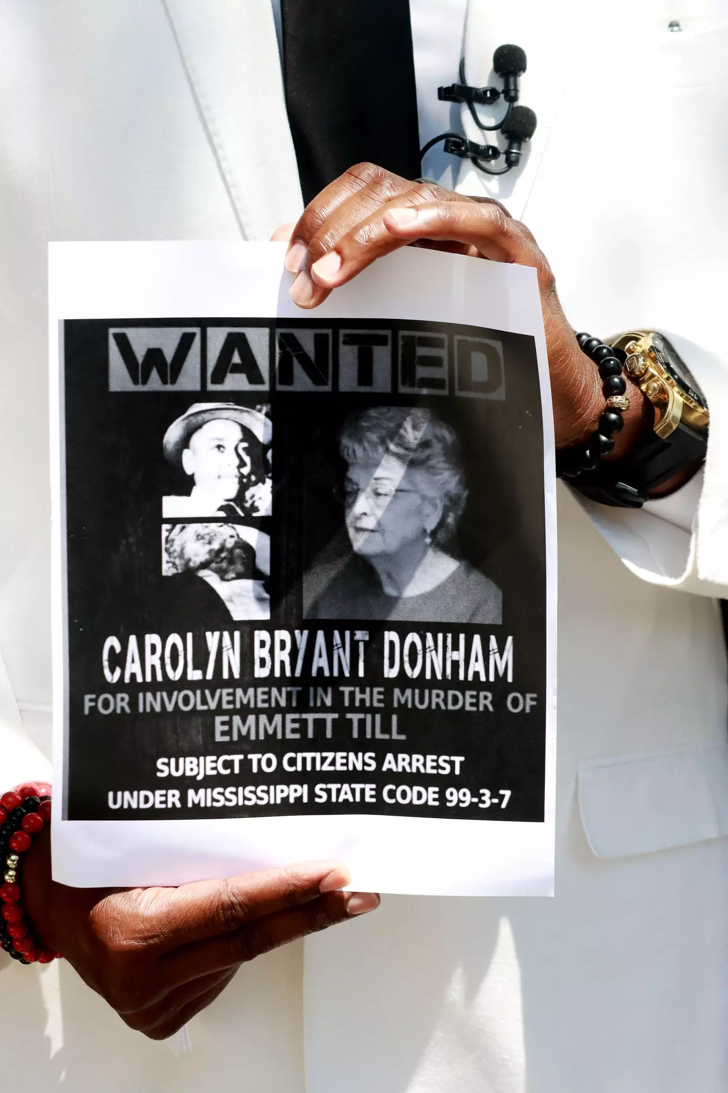 Civil rights activist John C Barnett holds up a wanted poster calling for the arrest of Carolyn Bryant Donham.