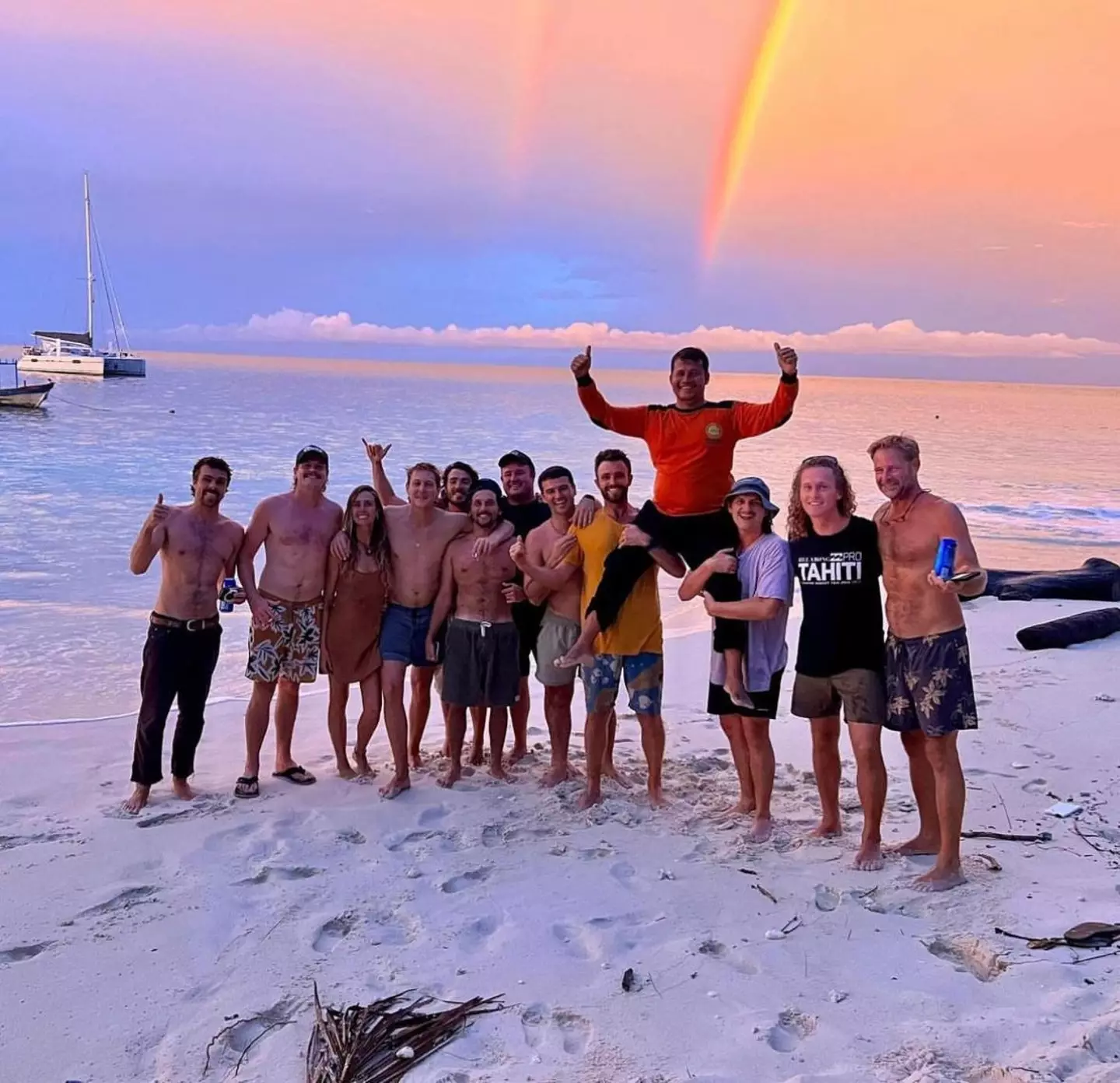 Grant Richardson, of the Sea Mi Amori, crew (pictured far right), while Elliot and a friend lift hero Indonesian native Yustinus into the air - the captain who found five out of the seven the missing members of the shipwreck (Courtesy of Elliot Foote)