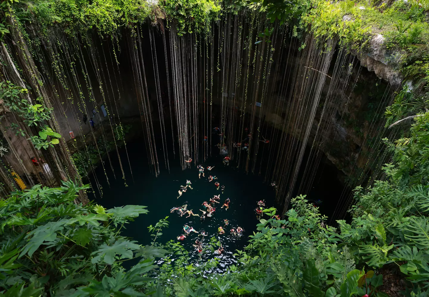 Tourists swim in the Ik-Kil cenote, one of the most visited due to its proximity to the Mayan ruins of Chichen Itza on July 16, 2022 in Piste, Mexico.