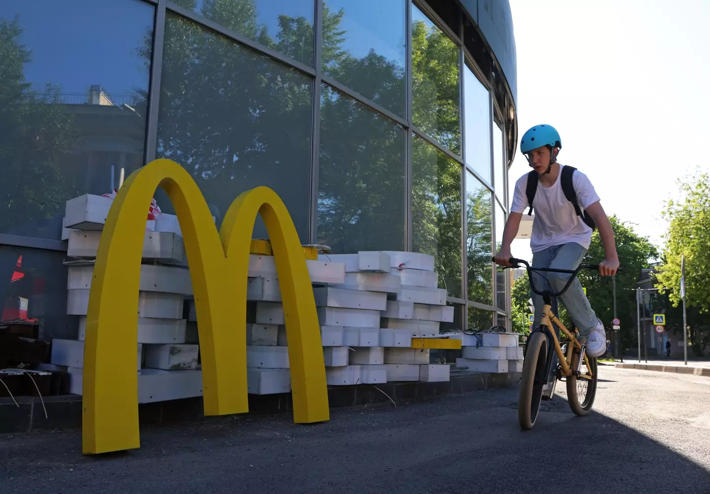 A child cycles past a closed down McDonald's in St Petersburg.