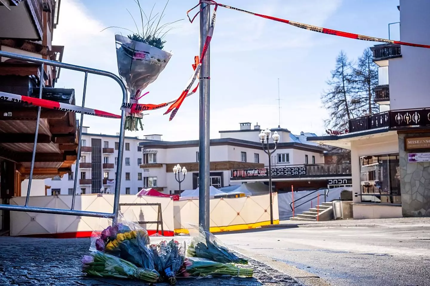 Flowers are seen laid alongside candles near the bar as several dozen are believed dead - with around 100 others injured (MAXIME SCHMID / AFP via Getty Images)