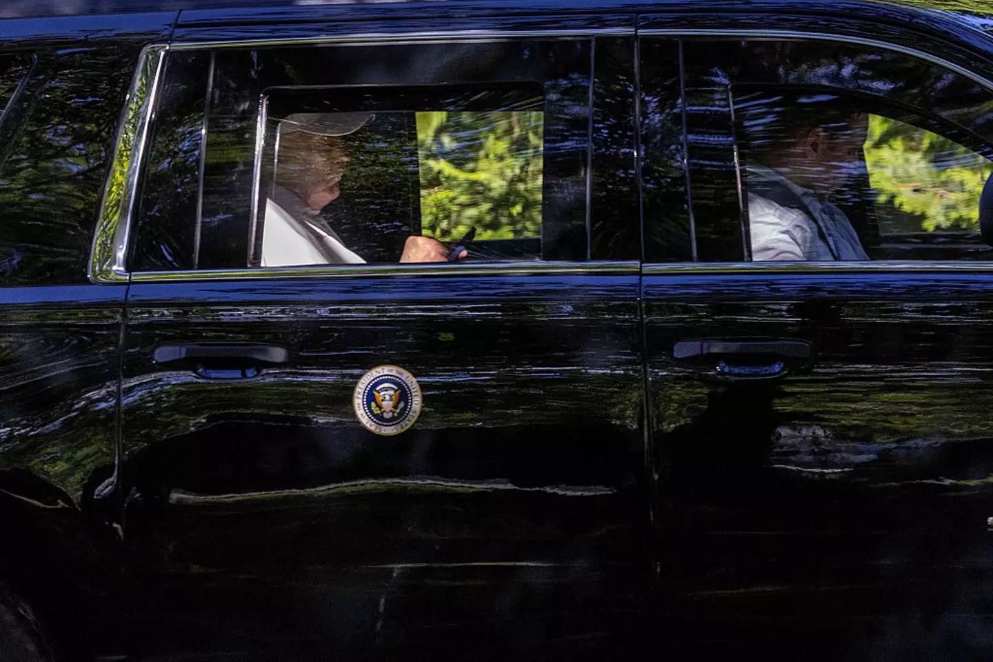 President Donald Trump checks his phone on Sunday, having spent the day at Trump National Golf Club (Tasos Katopodis/Getty Images)