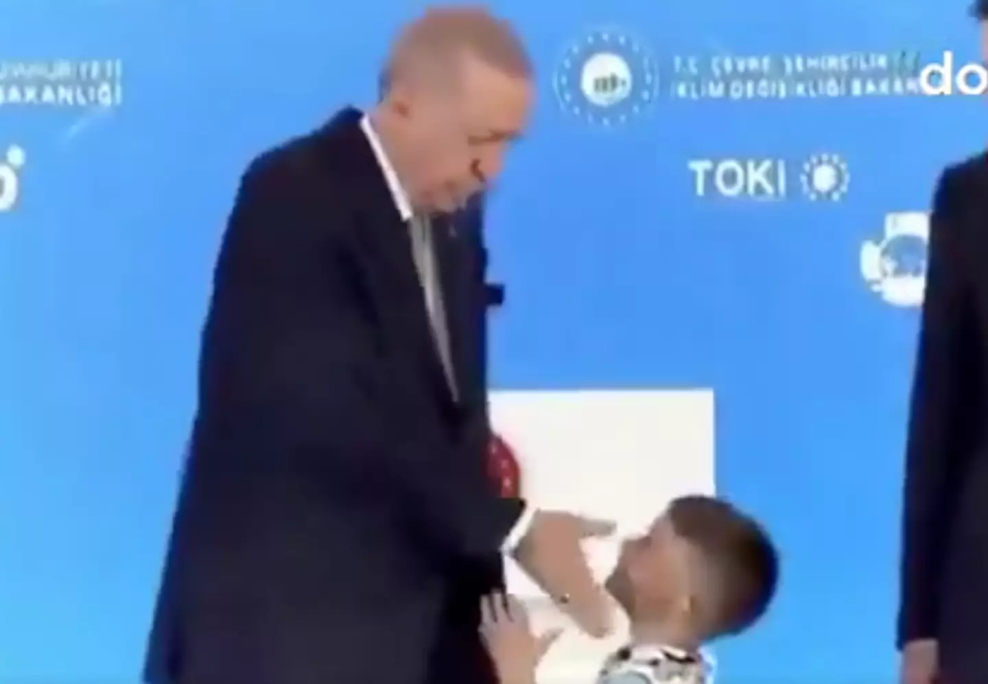 The president can be seen raising his hand and touching the side of the boy's face (Dokuz 8 TV)