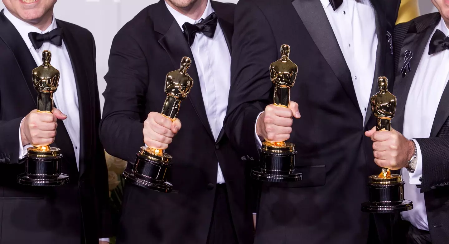 Men holding Oscars statues (Alamy)