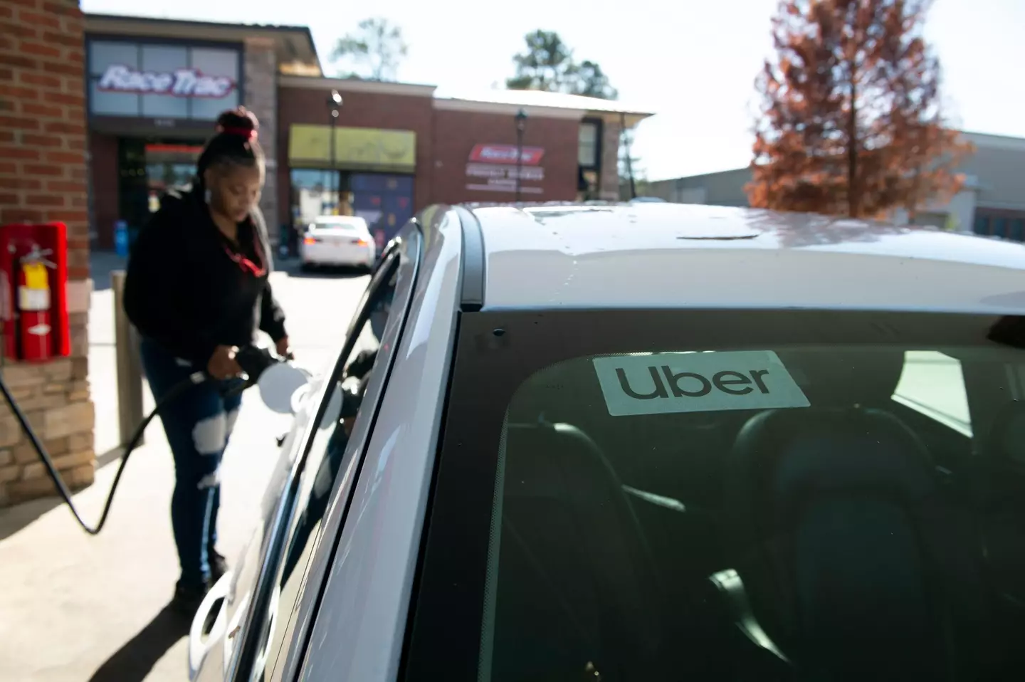 Uber driver filling up her car (Alamy)